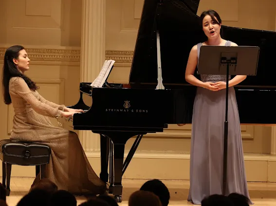 Maria Kolosova performing at the Mannes Sounds Festival, accompanying a vocalist on a Steinway grand piano